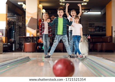 Little children playing bowling in club