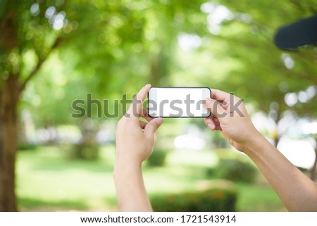 A man is holding cell phone on green 