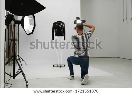 Professional photographer taking picture of ghost mannequin with stylish clothes in modern photo  Royalty-Free Stock Photo #1721551870