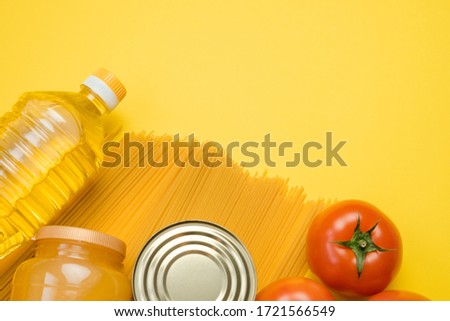 Various common groceries on yellow background. Shopping for products, delivery or donation, food shelf stock for quarantine and lockdown period. Long term food supply. Top view, free space. 