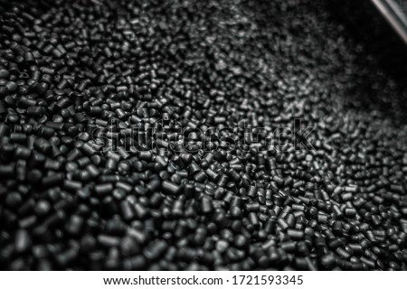 Black polypropylene granule close-up background texture. Black chemical granules for industrial plastic production. Royalty-Free Stock Photo #1721593345
