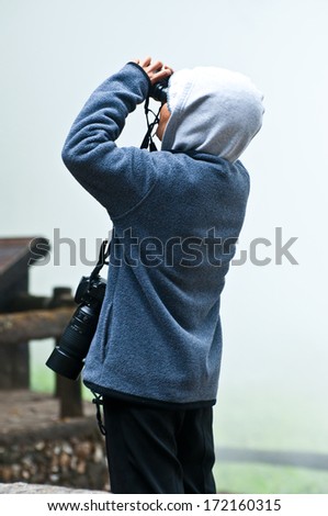 Birdwatcher with  binoculars and camera