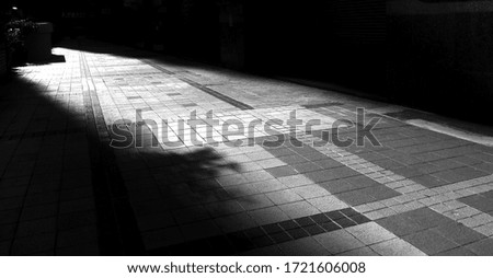 Shadows caused by the evening sun passing through tall buildings and reflecting on concrete(Black and white photo)