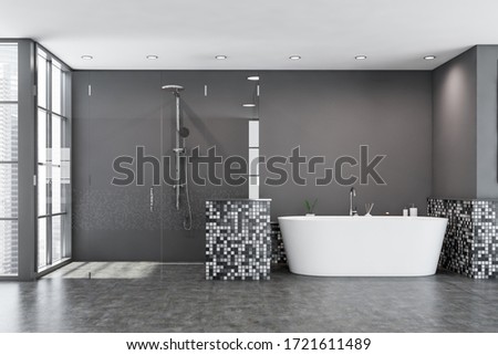 Interior of modern bathroom with grey mosaic walls, concrete floor, window with blurry cityscape, cozy bathtub and comfortable glass shower stall. 3d rendering