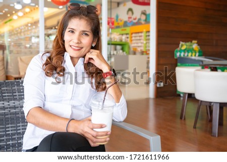 Asian woman with coffee glass, Thailand.