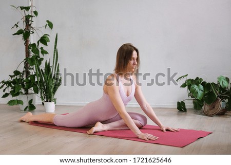 A woman does hatha yoga at home during the quarantine.