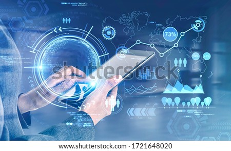 Hand of businesswoman using tablet in blurry room with double exposure of futuristic online work interface. Toned image. Elements of this image furnished by NASA