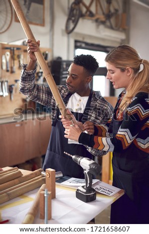 Multi-Cultural Team In Workshop Assembling Hand Built Sustainable Bamboo Bicycle Frame Royalty-Free Stock Photo #1721658607