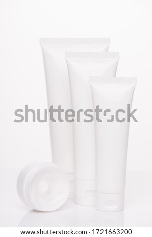 Therapy bodycare freshness nature concept. Vertical photo of collection of different size tubes with cream isolated over pure white background