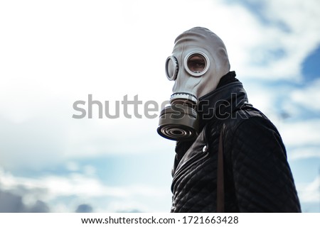 casual young man in a gas mask standing on the street in an empty city Royalty-Free Stock Photo #1721663428