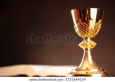 Catholic symbols on the table. Chalice, cross, bible. Royalty-Free Stock Photo #1721664154