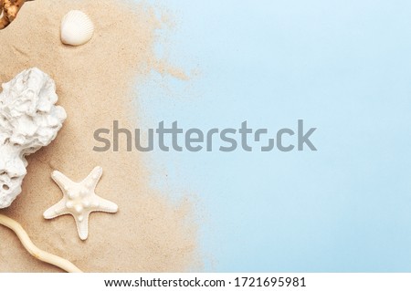 Golden sand and marine decorations. Seashell, starfish and sea stone. Copy space in right side. Isolated blue background. Summer vacation and travel concept Royalty-Free Stock Photo #1721695981