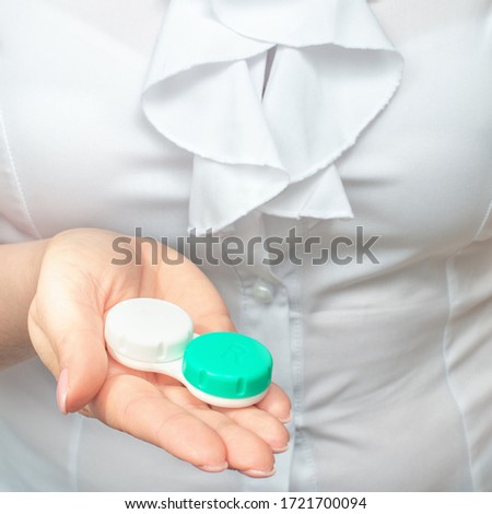 Eyesight and eyecare concept. Closeup Of Woman Hands Holding White Eyelense Container.
