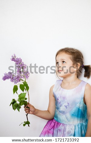 little girl in a dress with a branch of lilac, blooming branch, baby, daughter, beauty