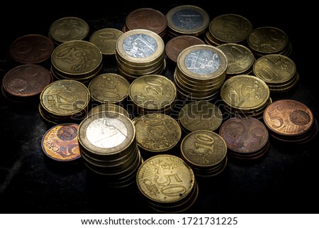 pile of euro coins with high contrast and bright lighting seen from above with a black background