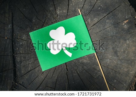 Flag with the image of clover lies on a stump in the forest