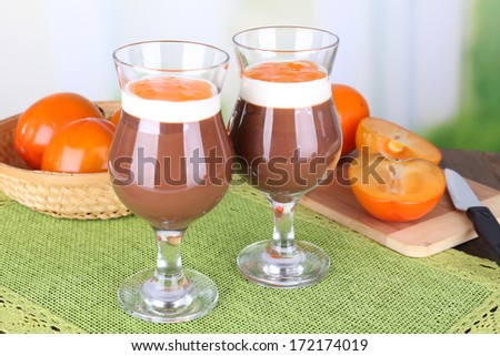 Dessert of chocolate and persimmon on table on light background