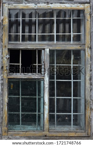 Old wooden window behind a metal grate. Vintage texture Royalty-Free Stock Photo #1721748766