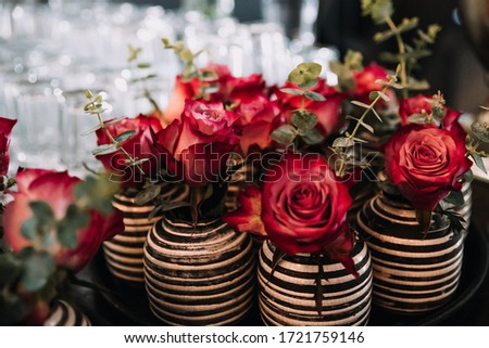 photo of red roses on a table in a vase