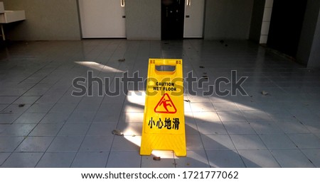 Warning signs for toilet cleaning progress, yellow signs warn the floor is wet (Chinese meaning: Attention, the floor will slip)