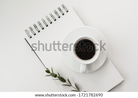 A place to work. Work desk, coffee on the table, glasses, notebook for writing notes. White background, minimalism empty space for notes.