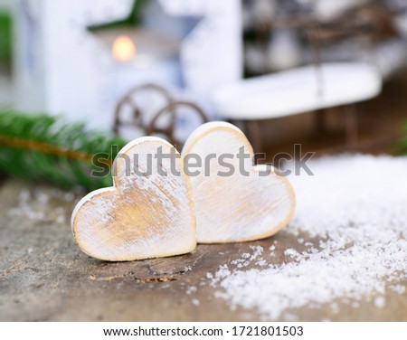 Two hearts and snowflakes on wooden background, closeup.