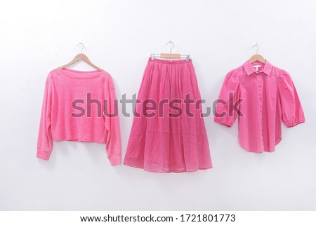 female fashion pink clothes and pink long skirt and sweater on white background


