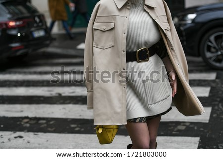 Street style outfit – Woman wearing a knitted dress matched with a black belt and a pastel leather jacket – StreetStyleFW2020 Royalty-Free Stock Photo #1721803000