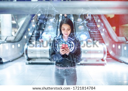 Woman using smartphone, network and communication, modern background - Asian young woman with empty escalator at train station connecting to fast internet - technology and 5g development