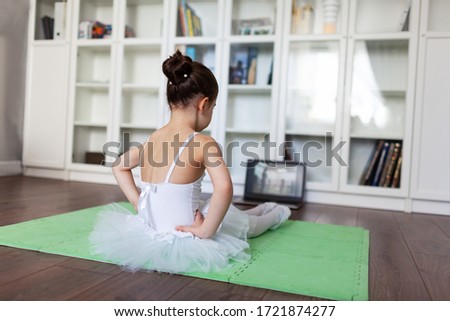 Pretty young ballerina practicing classic choreography during online class in ballet school, social distance during quarantine, self-isolation, online education concept Royalty-Free Stock Photo #1721874277