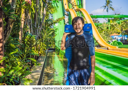 Coronavirus is over. Quarantine weakened. Take off the mask. Now you can go to public places. Dad and son have fun at the water park