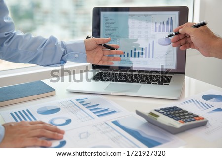Financial analyst analysis business financial report on digital tablet during discussion at meeting of corporate showing the results of their successful teamwork. Royalty-Free Stock Photo #1721927320