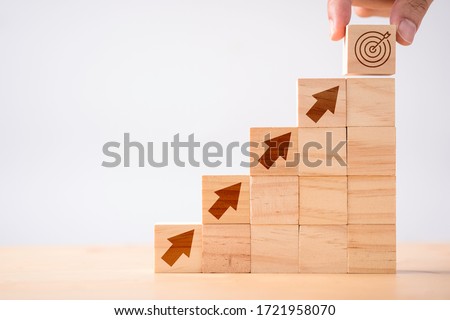 Hand putting print screen dart and target board wooden cube on up arrows. Target of investment and business concept. Royalty-Free Stock Photo #1721958070
