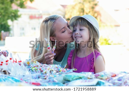 Lovely mother and daughter having fun at a festival



