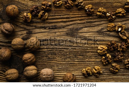 Walnut scattered on the wooden vintage table. Walnuts is a healthy vegetarian protein nutritious food. Walnut on rustic old wood.