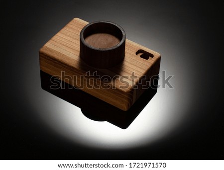 Wooden toy camera on dark background.Eco friendly toys concept.