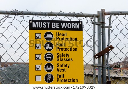 Protective equipment requirement sign at the construction site.