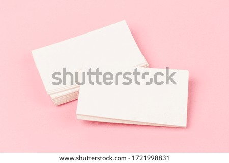 stacks of white blank business cards on pink  background in close-up