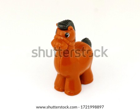 Cute brown toy horse with a black tail and a mane, photographed close-up in the studio