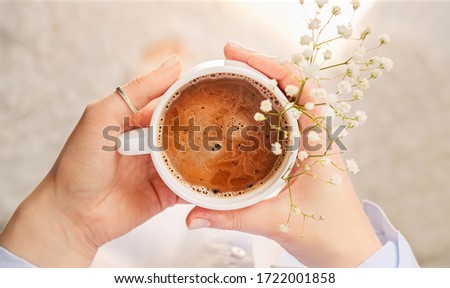 Cup of fragrant morning coffee in a cozy atmosphere of home. Close-up of holding hot ceramic white coffee cup. Good morning.