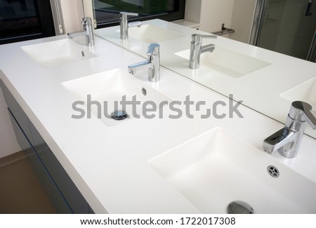 Three sink bathroom with three washbasin and three faucet white modern design with mirror close-up