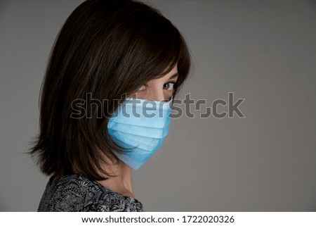 Portrait of a girl with surgical mask during Coronavirus lockdown with gray background