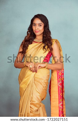 beautiful charming Indian model, woman standing wearing saree, indoor lighting