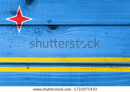 Aruba flag painted on old wood plank background. Brushed natural light knotted wooden board texture. Wooden texture background flag of Aruba.