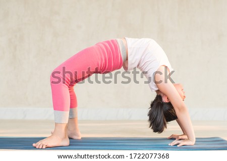 calmness and relax, female freedom happiness. home practice room background. little asian girl meditates while practicing yoga. child happiness. toned picture healthy life. yoga concept.