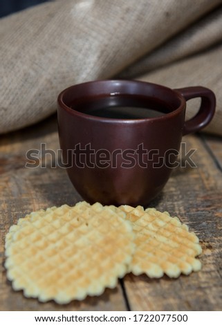 Coffee on a wooden table. Waffles are round. Breakfast