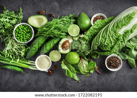 Top view of healthy organic food: green vegetables, seeds and herbs on dark background. Source of protein for vegetarians. Royalty-Free Stock Photo #1722082195