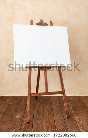Wooden easel with white canvas blank in studio. Copy space for your text