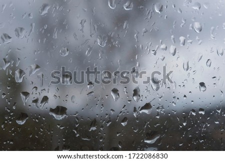 There are large raindrops on the window pane.