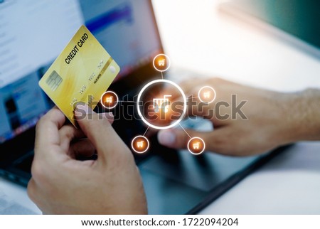 Man's hands holding a credit card and using laptop for online shopping and online payment via internet. Technology concept.